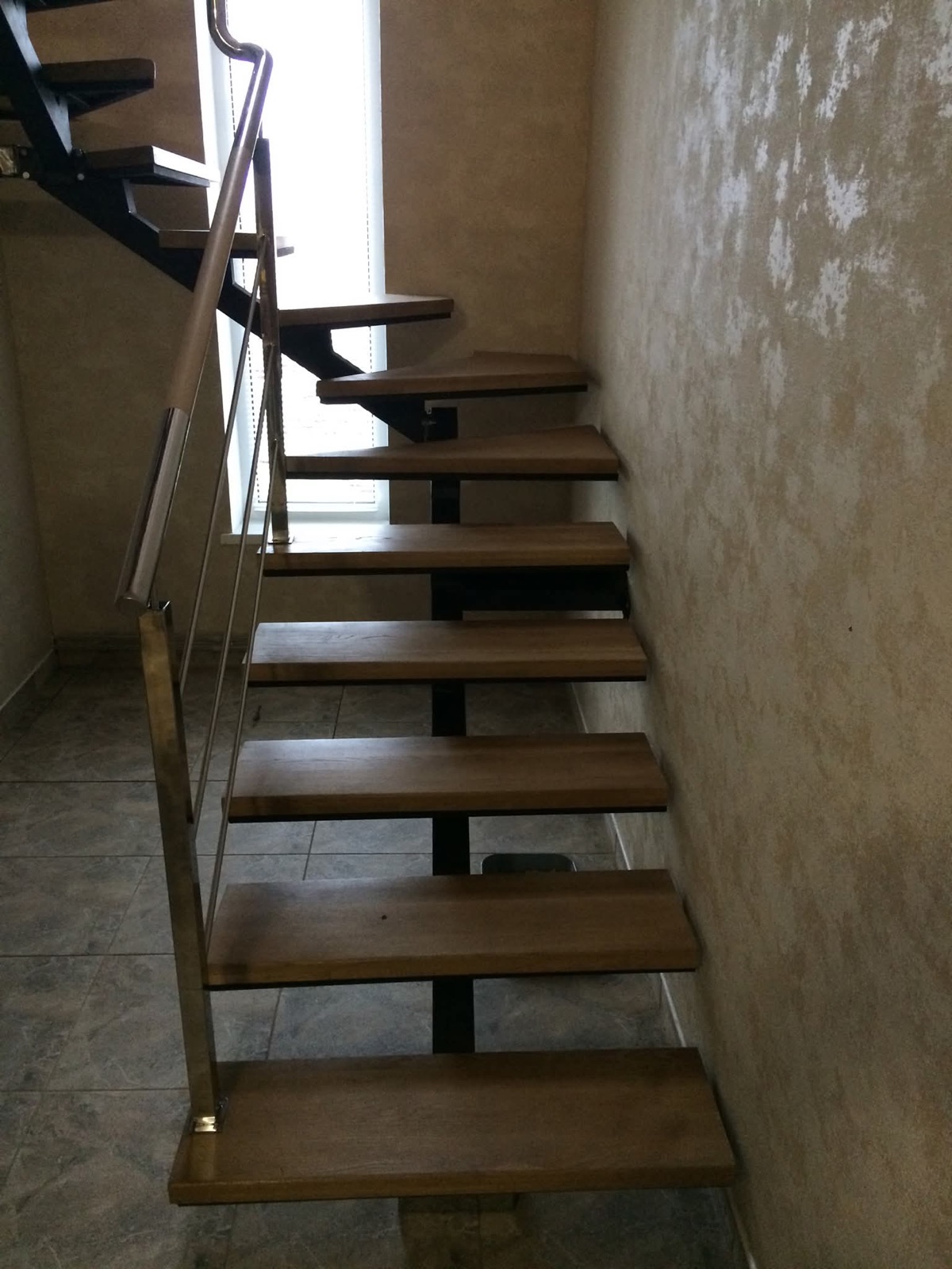 Schody kręcone ze stopniami ze stali ryflowanej w industrialnym wnętrzu