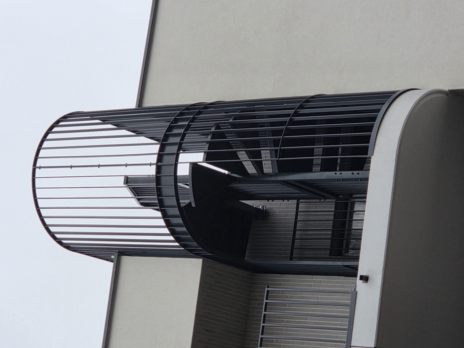 Ocynkowane schody kręcone zewnętrzne przy elewacji budynku — realizacja Factory Welding
